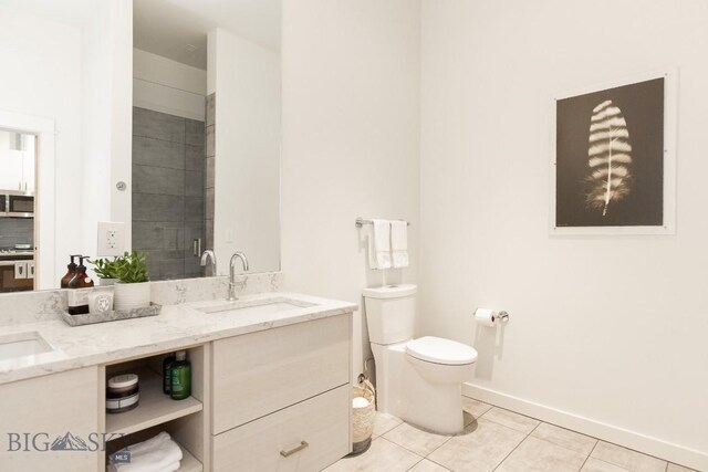 bathroom featuring tile patterned flooring, vanity, a shower with shower door, and toilet