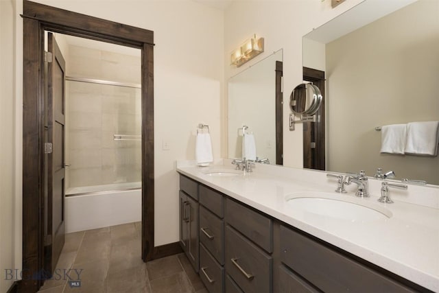 bathroom with tile patterned floors, vanity, and bath / shower combo with glass door