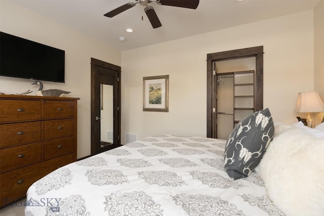 bedroom with ceiling fan, a walk in closet, and a closet