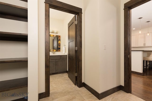 corridor with sink and light tile patterned flooring