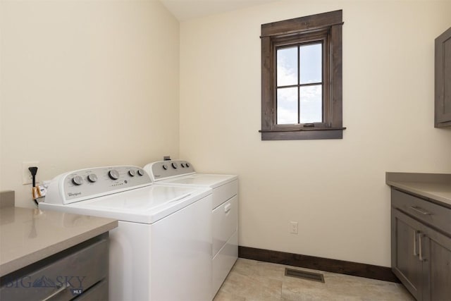 washroom featuring cabinets and separate washer and dryer