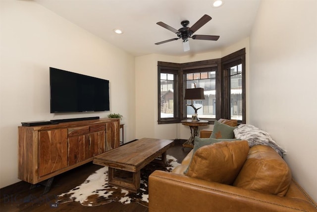 living room with dark hardwood / wood-style flooring and ceiling fan