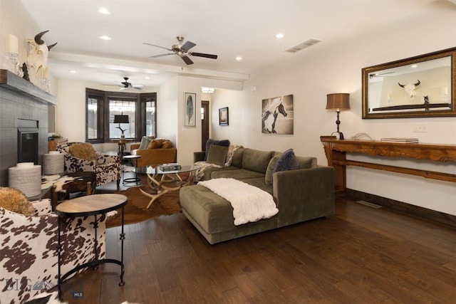 living room featuring ceiling fan, dark hardwood / wood-style flooring, and a fireplace