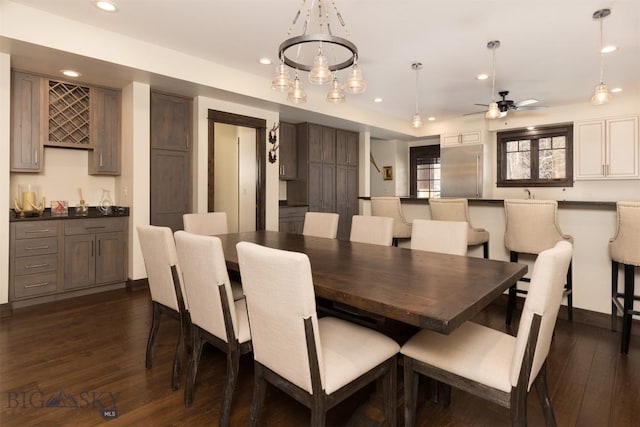 dining area with ceiling fan and dark wood-type flooring