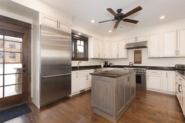 kitchen featuring ceiling fan, sink, dark hardwood / wood-style floors, white cabinets, and high end appliances