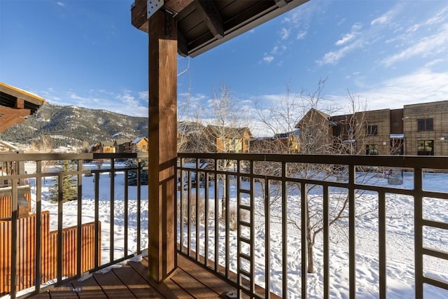 snow covered back of property with a mountain view