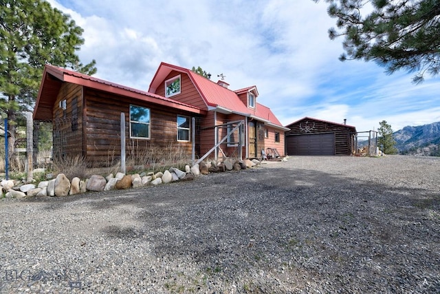 cabin with a garage and an outdoor structure