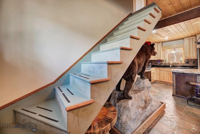 stairway featuring sink and wooden ceiling