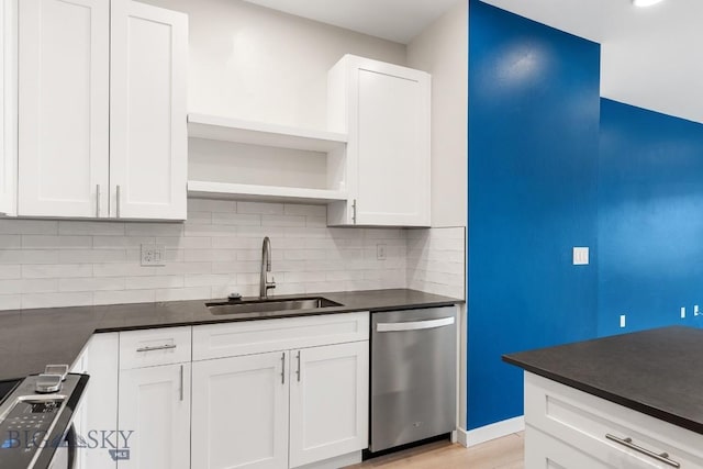 kitchen with open shelves, stainless steel appliances, dark countertops, decorative backsplash, and a sink