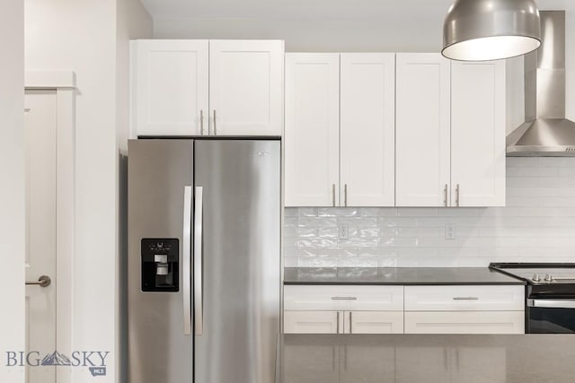 kitchen featuring appliances with stainless steel finishes, white cabinets, decorative backsplash, and wall chimney exhaust hood