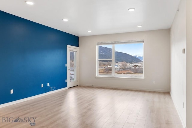 spare room with recessed lighting, wood finished floors, and baseboards