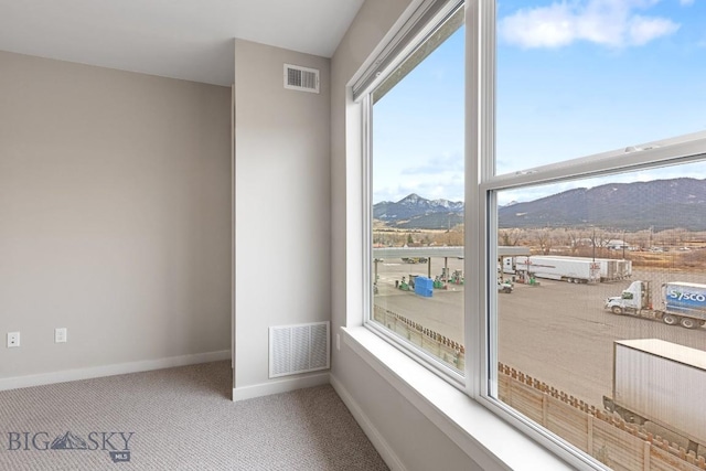 interior space featuring a mountain view, carpet floors, visible vents, and baseboards