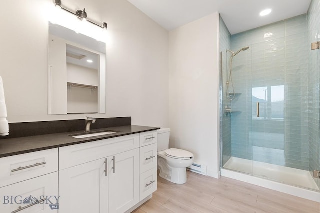 full bathroom featuring a baseboard radiator, toilet, wood finished floors, vanity, and a stall shower