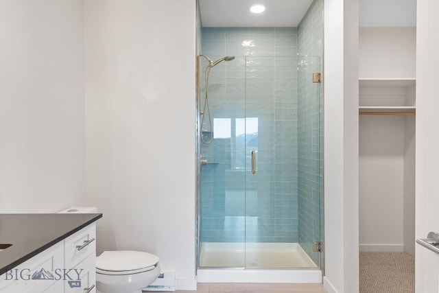 full bathroom featuring toilet, a stall shower, and baseboards