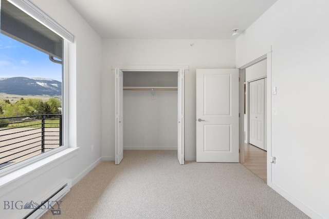 2221F Willow Unit 104, Livingston, MT 59047 - unfurnished bedroom featuring carpet flooring, a baseboard heating unit, a mountain view, and a closet
