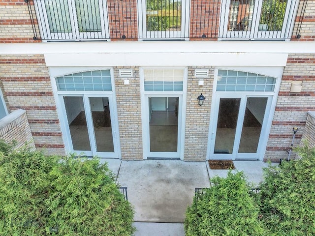 view of exterior entry with a patio area