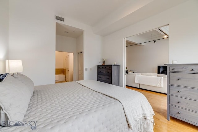 bedroom with light hardwood / wood-style floors and connected bathroom