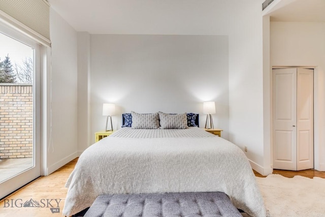 bedroom with access to exterior and light hardwood / wood-style flooring