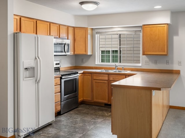 kitchen with kitchen peninsula, appliances with stainless steel finishes, and sink