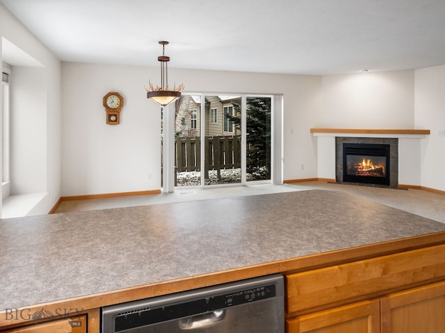 kitchen with a tile fireplace, dishwasher, and hanging light fixtures