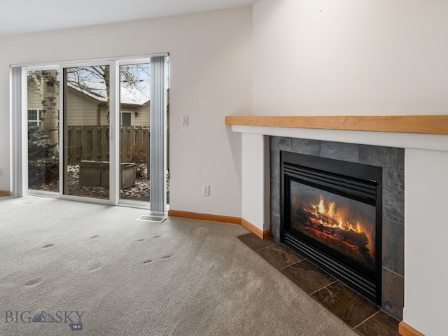 unfurnished living room with dark colored carpet and a fireplace