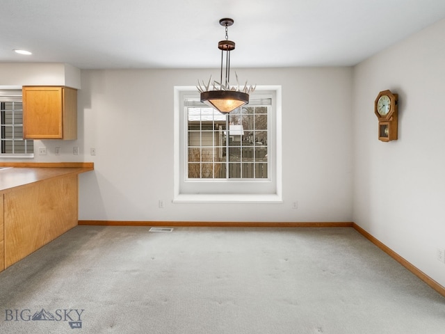 unfurnished dining area with light carpet