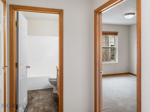 hallway with dark colored carpet