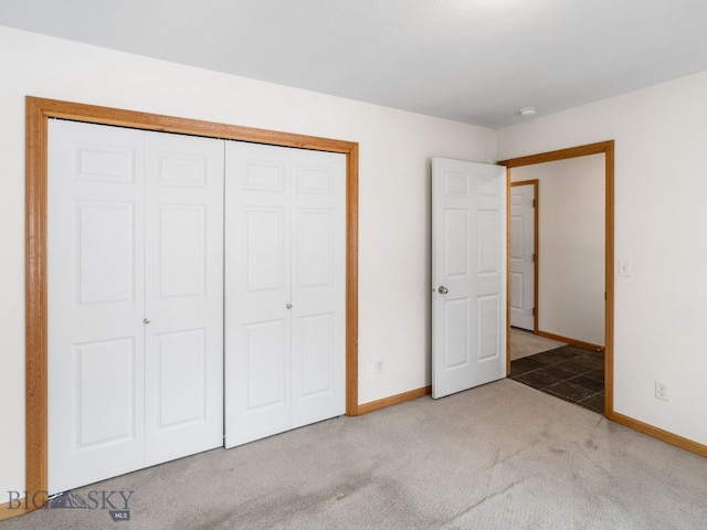 unfurnished bedroom with light colored carpet and a closet