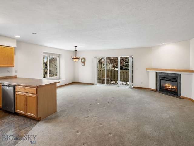 kitchen featuring dark colored carpet, pendant lighting, stainless steel dishwasher, and a healthy amount of sunlight