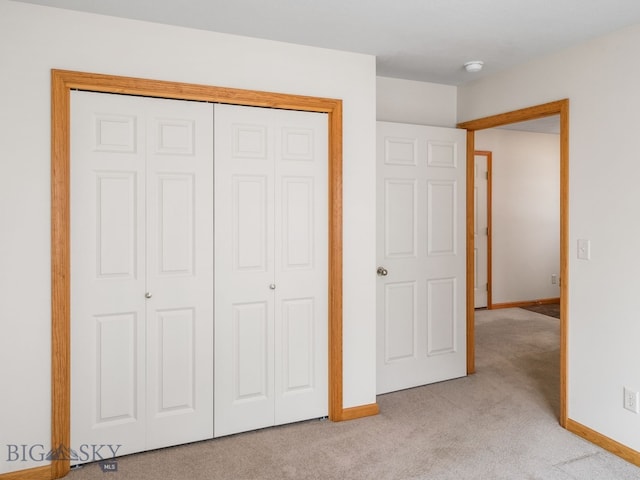 unfurnished bedroom with light carpet and a closet