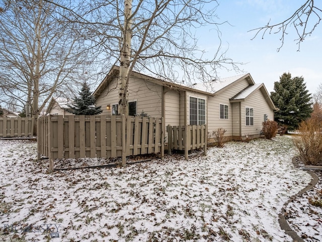 view of snow covered back of property