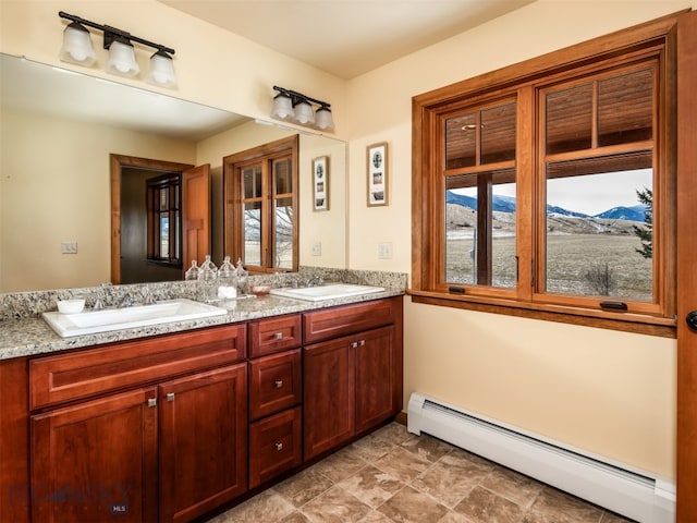 full bathroom with double vanity, a baseboard radiator, a sink, and a mountain view