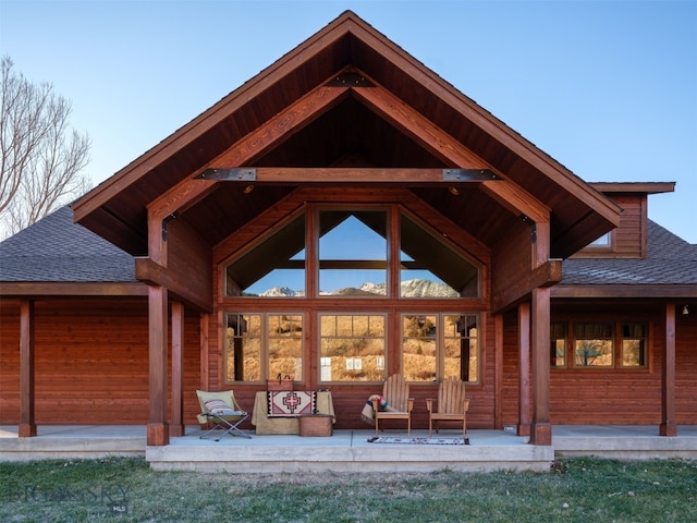 rear view of house with a shingled roof