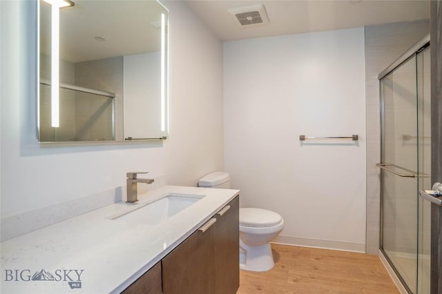 bathroom with walk in shower, toilet, vanity, and hardwood / wood-style flooring