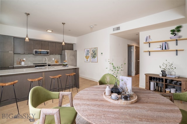 dining space featuring light wood-type flooring and sink