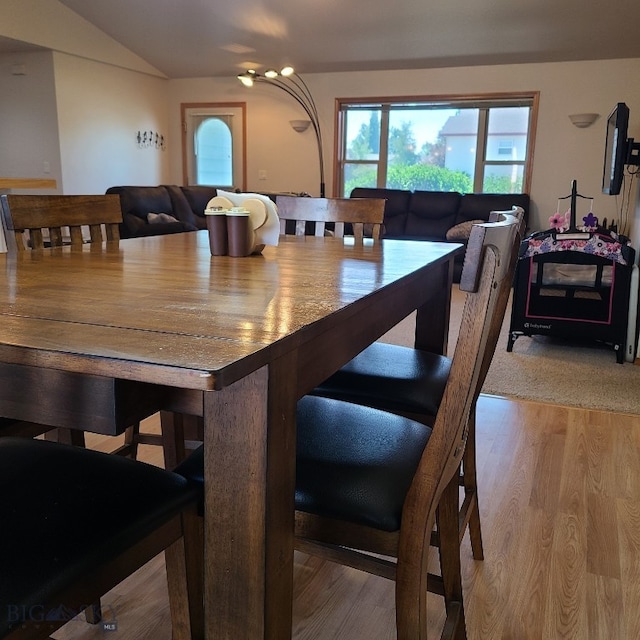 dining area with lofted ceiling and light wood-type flooring