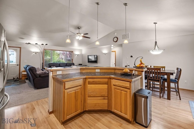 1311 Cruiser Ln, Belgrade, MT 59714 - kitchen featuring open floor plan, dark countertops, lofted ceiling, light wood-type flooring, and ceiling fan