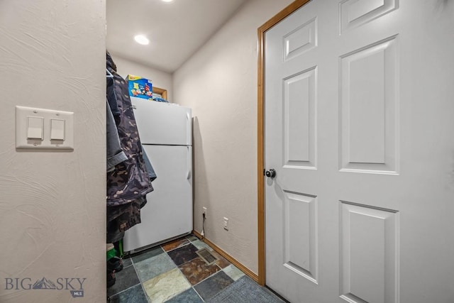 1311 Cruiser Ln, Belgrade, MT 59714 - laundry room with stone finish flooring and baseboards