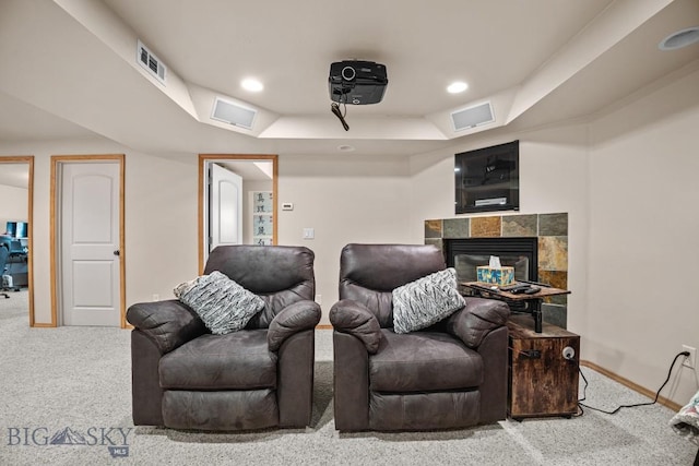 1311 Cruiser Ln, Belgrade, MT 59714 - cinema room featuring carpet flooring, a tray ceiling, a tiled fireplace, and recessed lighting