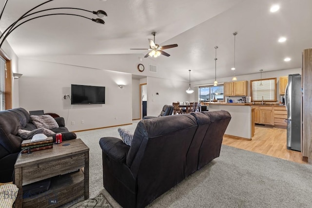 1311 Cruiser Ln, Belgrade, MT 59714 - living room with lofted ceiling, ceiling fan, light wood-style floors, recessed lighting, and light carpet