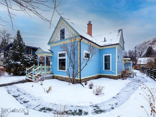 view of snow covered rear of property