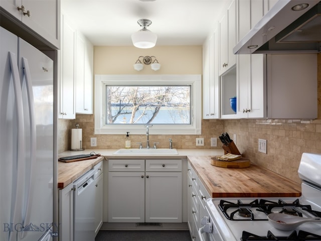 kitchen featuring butcher block counters, white cabinetry, sink, range hood, and white appliances