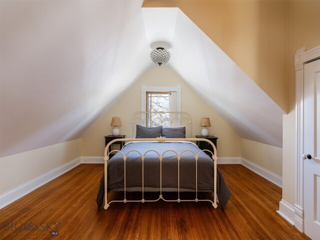 bedroom featuring vaulted ceiling and dark hardwood / wood-style floors