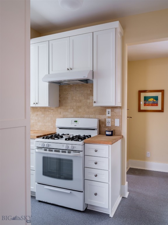 kitchen with white range with gas stovetop, backsplash, white cabinets, and butcher block counters