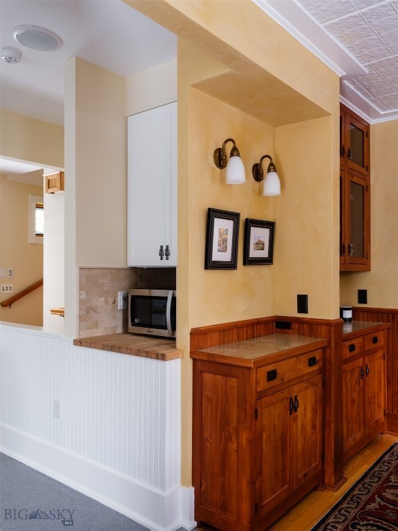 kitchen with backsplash, kitchen peninsula, and light hardwood / wood-style flooring