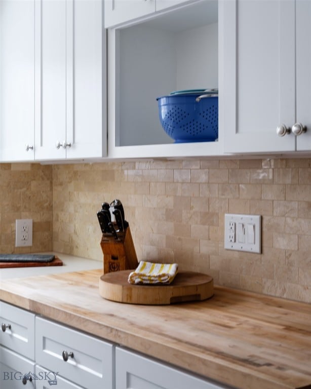 interior space with butcher block countertops, decorative backsplash, and white cabinets