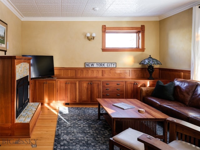 living room featuring hardwood / wood-style flooring, wooden walls, and ornamental molding