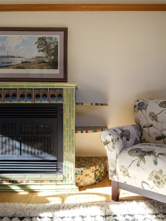 room details featuring a fireplace, wood-type flooring, and crown molding