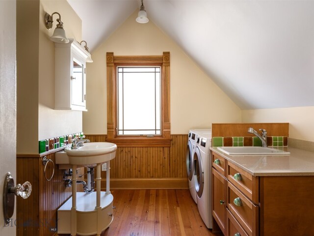 clothes washing area featuring separate washer and dryer, light hardwood / wood-style floors, and sink