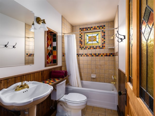 full bathroom featuring shower / bath combo with shower curtain, wooden walls, sink, and toilet